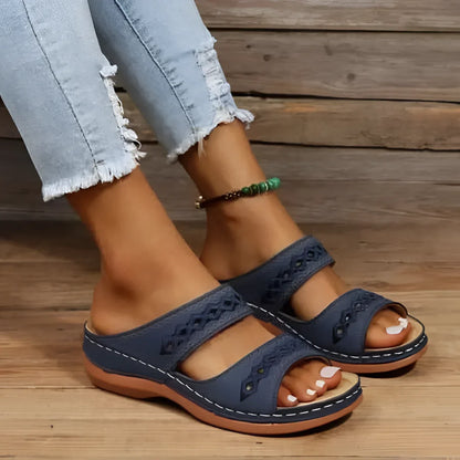 Sandales en cuir bleu marine avec découpes décoratives et semelle confortable.
